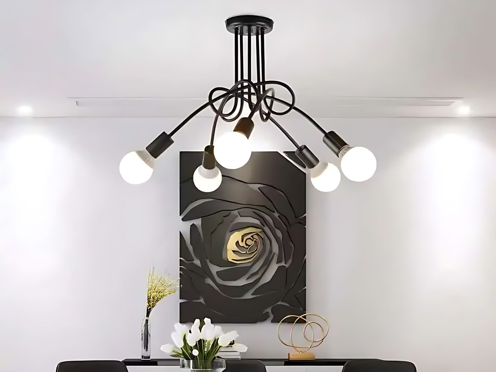 Lustre LED au style industriel Lustre LED au style vintage au-dessus d'une table de salle à manger noire. Sur le mur blanc du fond il y a un grand cadre noir et doré.