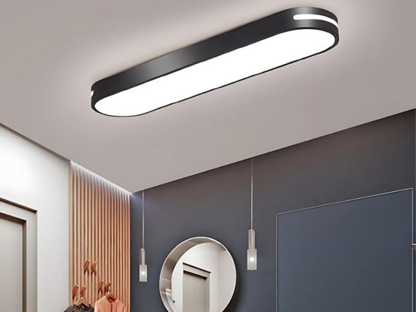 Le plafonnier LES ultra-mince sur un plafond gris au-dessus d'un miroir rond