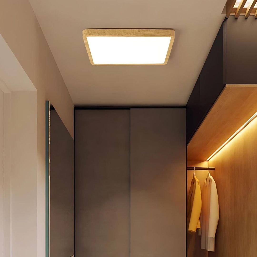 Plafonnier carré à LED connecté Le plafonnier carré à LED connecté en couleur bois, sur le plafond d'un couloir.