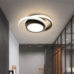 Le plafonnier à LED suspendu avec avec anneaux ronds au design moderne dans un couloir gris avec sur le mur droit une verrière.