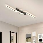 Plafonnier LED décoratif à lignes asymétriques Le plafonnier à LED décoratif à lignes asymétriques sur un plafond blanc. plusieurs cadres sont présents sur les murs.