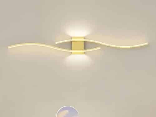 Applique murale LED au design minimaliste et moderne, composée de lignes ondulées et élégantes, diffusant une lumière douce et chaleureuse.