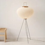 Lampadaire LED Japandi minimaliste chic Lampadaire LED japandi minimaliste chic en papier de riz blanc délicatement façonné et son trépied noir métallique sur fond uni beige