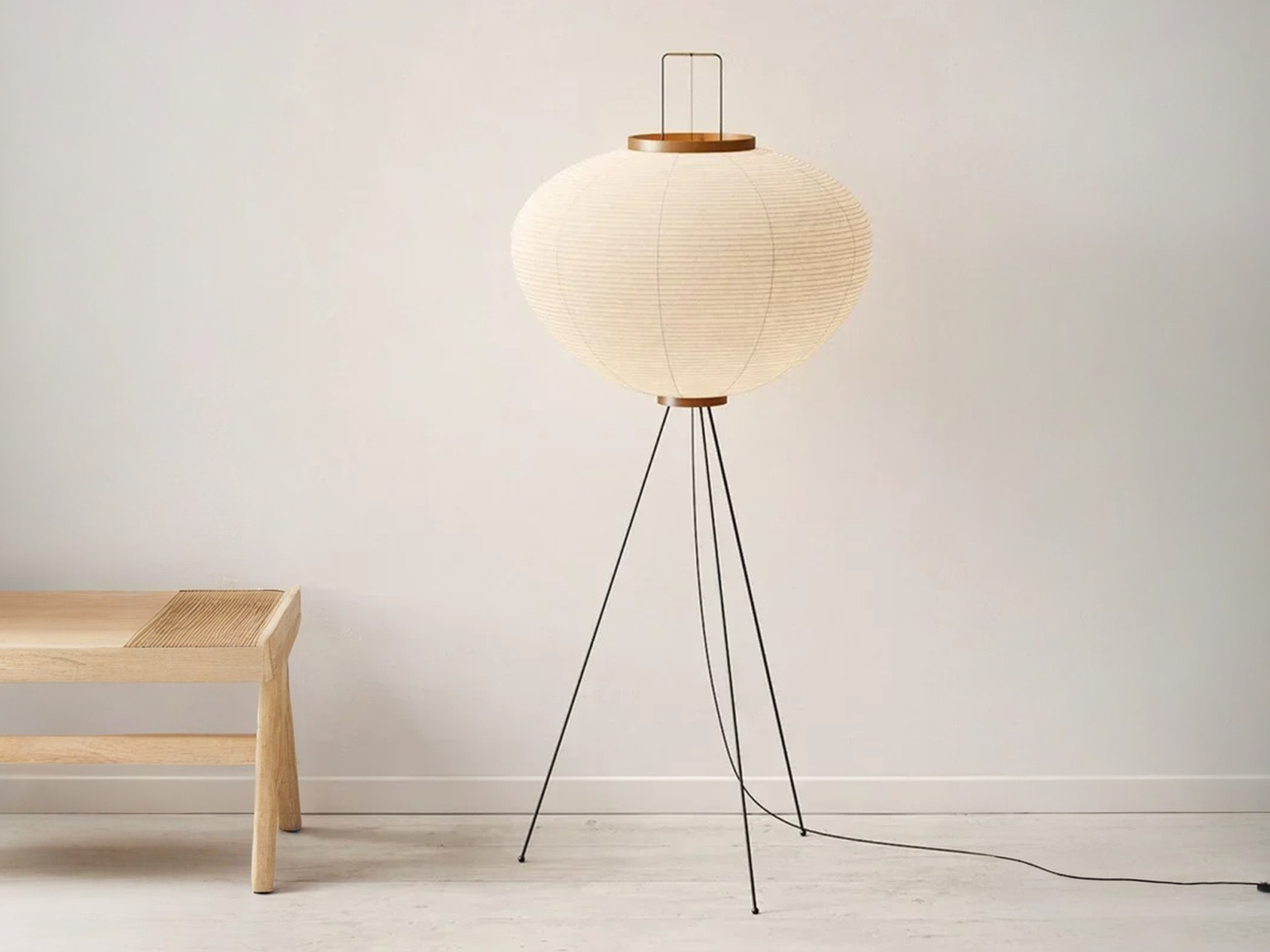 Lampadaire LED Japandi minimaliste chic Lampadaire LED japandi minimaliste chic en papier de riz blanc délicatement façonné et son trépied noir métallique sur fond uni beige