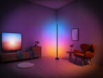 Lampadaire intelligent LED pour angle immersif RGB, design minimaliste noir mat, lumière connectée multicolore pour ambiance personnalisée, dans un salon moderne.