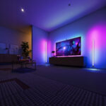 Lampadaire LED d’angle intelligent ambiance créative Lampadaire LED d’angle intelligent en forme de tube, sur pied, design minimaliste noir, lumière RGB personnalisable dans un salon moderne.