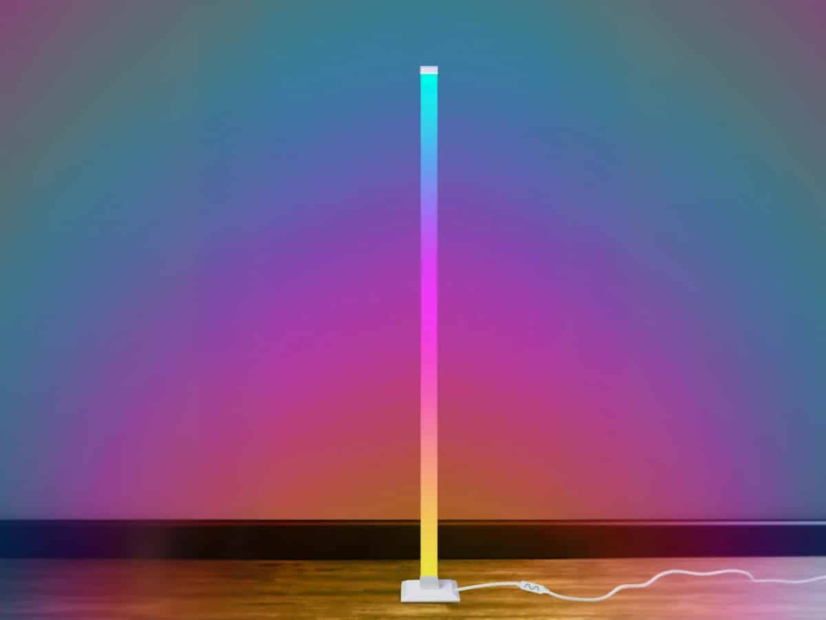 Lampadaire LED d’angle intelligent avec lumière rythmée, design vertical blanc pour ambiance lumineuse immersive en situation dans une pièce sans mobilier.
