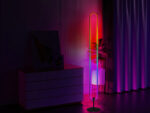 Lampadaire LED intelligent d’angle pour expérience sensorielle, design ovale moderne et lumière RGB contrôlable par appli, télécommande ou commande vocale dans un salon moderne.